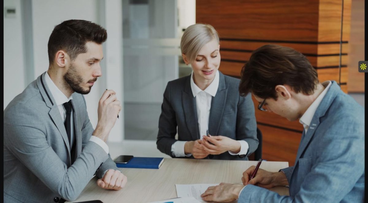 Legal employer and recruiter discussing contingency vs retained recruiting terms at a desk